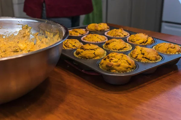 Zelfgemaakte muffins in een muffin tray in de buurt van een kom met muffin batter — Stockfoto