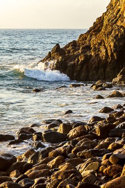 gündoğumu ile Shoreline kayalar üzerinde dalga kırma 