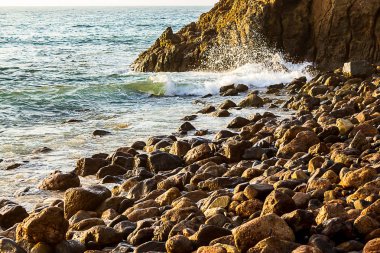 gündoğumu ile Shoreline kayalar üzerinde dalga kırma 