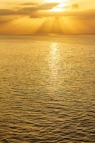 Extensão do oceano ao nascer do sol com raios solares e nuvens — Fotografia de Stock