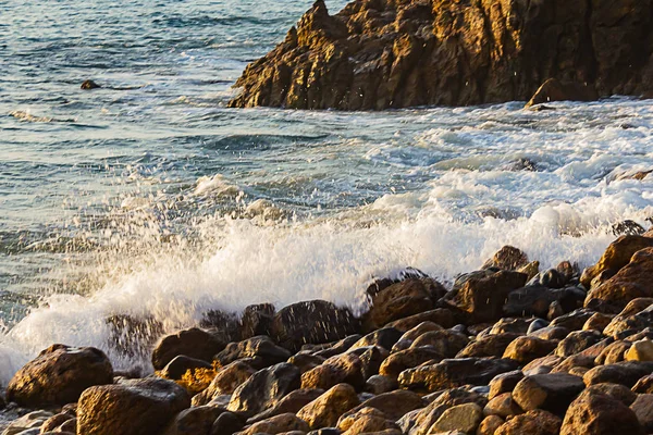 Onda quebrando em rochas na costa com o nascer do sol — Fotografia de Stock