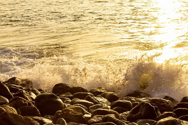 Sarı yansıma ile gündoğumu içinde Shoreline dalga sıçrama — Stok fotoğraf