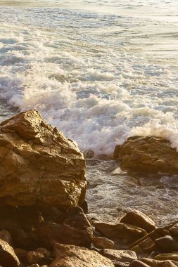okyanus kıyısında booulders ve kayalar doğru köpükpastel dalga yıkama