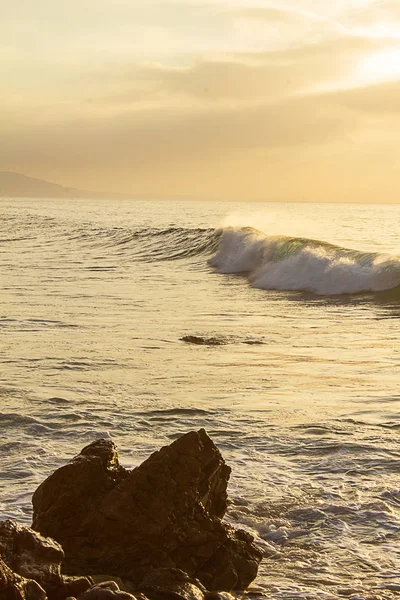 Onda de ondulação quebrando no oceano pacífico ao nascer do sol — Fotografia de Stock