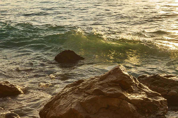 Ondulación que se forma con luz verde y amarilla transparente que se mueve hacia las rocas —  Fotos de Stock