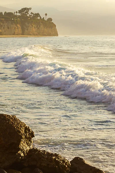 Onda espumante quebrando no oceano espanse com penhasco e pedras — Fotografia de Stock