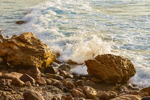 Schuimende Golf breuk bij zonsopgang met rotsachtige kustlijn — Stockfoto