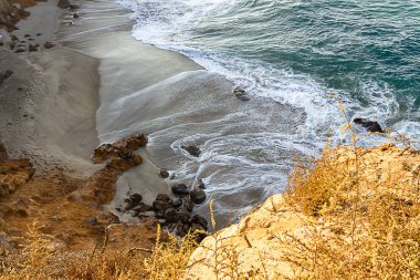 kumtaşı yol uçurum tarafına bakan, kumlu bir plajda pacfic okyanus dalgaları, kayalar