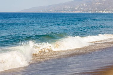 sıçrayan dalga, okyanus genişlik üzerinde bir şişme dalga takip, kumlu bir plajda backwash köpük