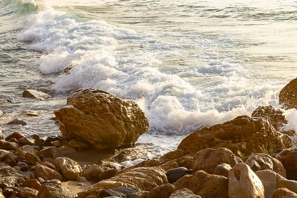 Kayalık kıyı şeridi ile gün doğumunda köpüklü dalga kırma — Stok fotoğraf