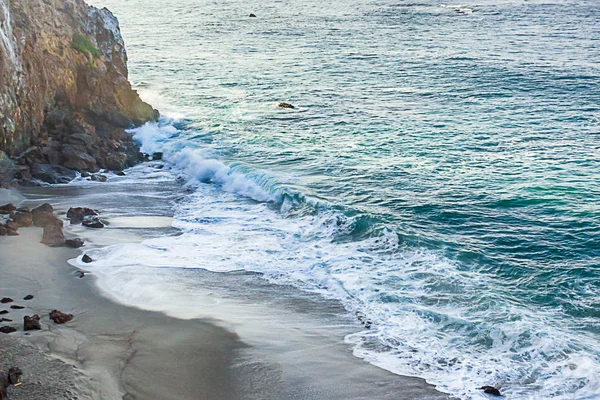 Vista aérea de ondas quebrando na costa arenosa com rochas — Fotografia de Stock