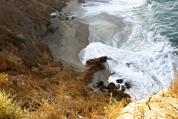 Caminho de arenito com vista para o lado do penhasco, ondas pacíficas do oceano em uma praia de areia, rochas — Fotografia de Stock