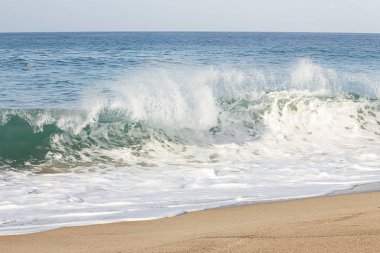 kumlu bir kıyı şeridinde kırma backwash köpük ile backspray tepe dalga