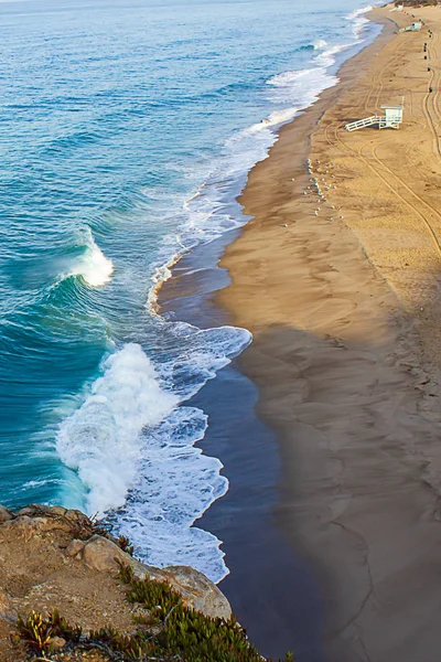 cliff top view of california beach shoreline waves breaking into distance