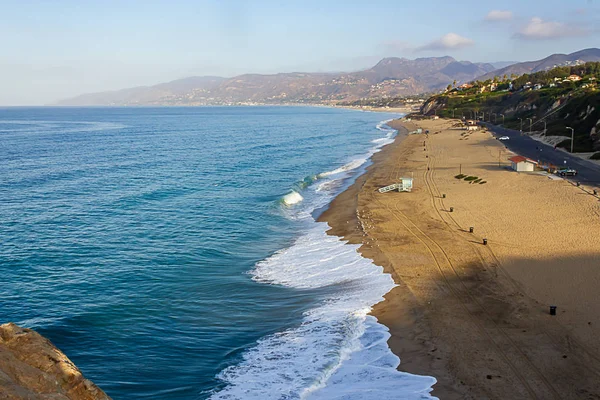 cliff top view of california beach shoreline waves breaking into distance