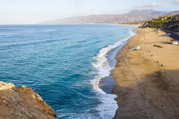 cliff top view of california beach shoreline waves breaking into distance