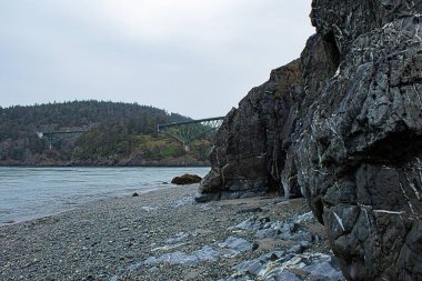 yeşil kemerli köprü ile sahil kayalıkları geçiyor