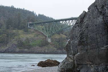 kıyı şeridi boyunca giden kemerli bir köprü ile sahil kayalıkları