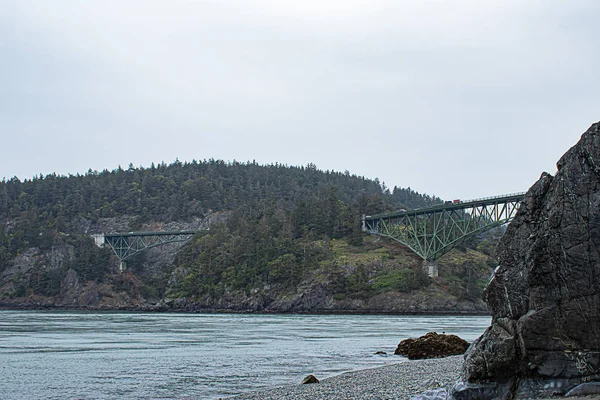 Klippen am Meer mit einer grünen Brücke entlang der Küste — Stockfoto