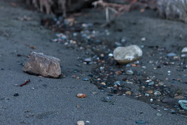 Arena fina y húmeda con pebles en un chorrito de agua — Foto de Stock