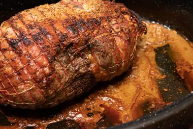 Fırın tavada oturan bağları ile Kuzu rostosu haddelenmiş