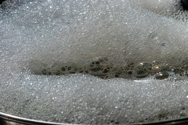 Primer plano de suds y burbujas en olla de plata —  Fotos de Stock