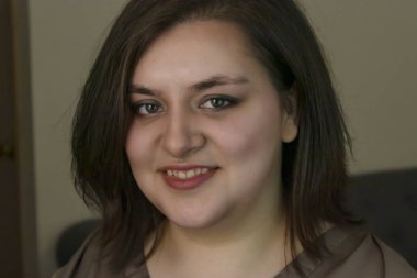 evde oturan güzel kız yüzünde büyük bir gülümseme