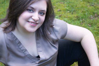 çim üzerinde gülümseyen dışında oturan kız ile bahar