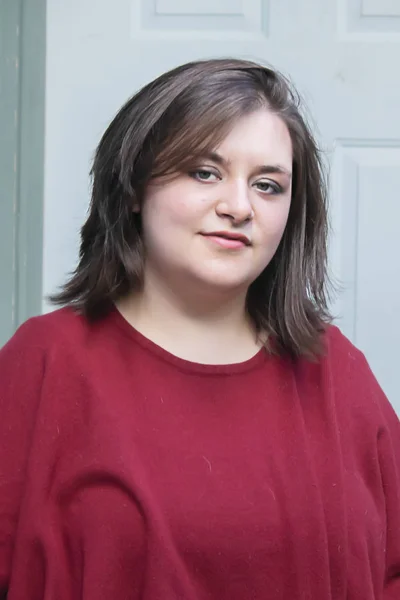 Klarröd skjorta på en tjej som sitter framför ytterdörren — Stockfoto