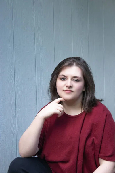 Bella ragazza con la mano sotto il mento davanti a casa — Foto Stock