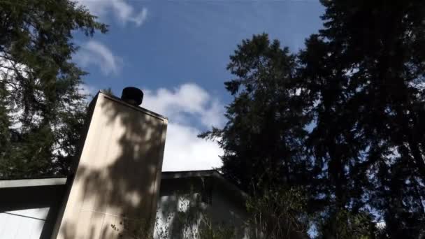 Arriba de la casa con árboles y nubes soplando sobre ella — Vídeo de stock