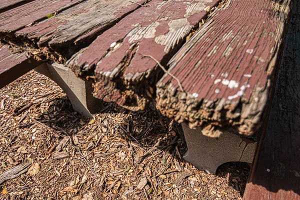 Aged rough weathered picnic table in park on mulch — Stock Photo, Image