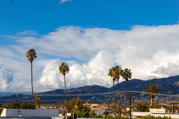 Budynek Glendale, domy i wzgórza prowadzące do gór San Gabriel, z błękitnym niebem i wysokimi chmurami — Zdjęcie stockowe