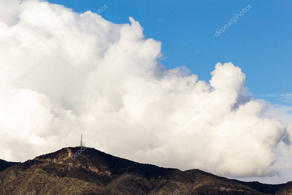 san gabriel mountains with large white dense cloud in blue sky