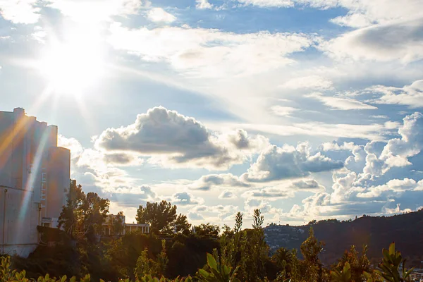 Zonnestralen van zonlicht, sunflare over heuvel planten en heuvel huizen — Stockfoto