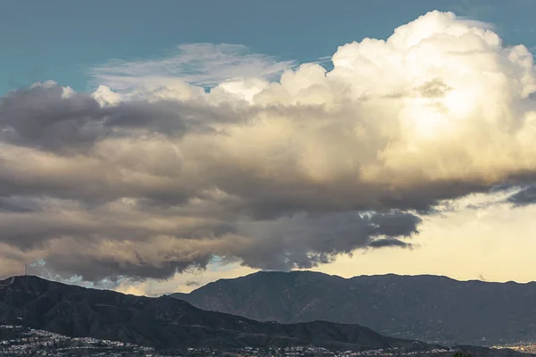 Горы с домами облака с кучевой, Нимб облака с голубым небом — стоковое фото