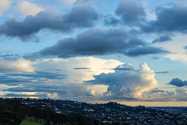 Widok na wzgórzu cmentarz z domów hillide, horyzont, i panaramic zachmurzone niebo — Zdjęcie stockowe