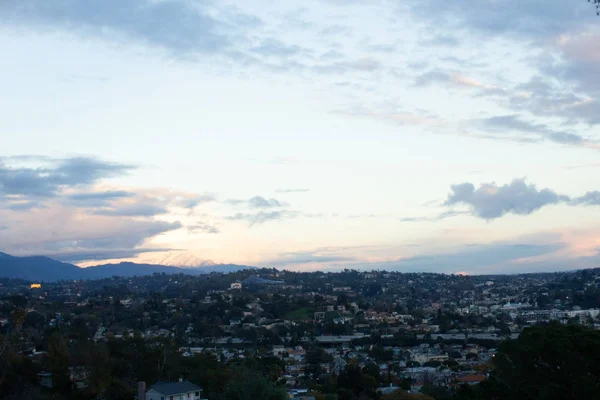 Suburban sprawll of homes through valley to distant mountains with large sky — Stock Photo, Image