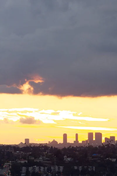 Vzdálené věže v záři západu slunce s panoramatickým výhledem na žluté sluneční paprsky na červené záři — Stock fotografie