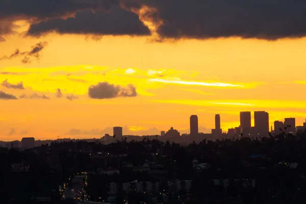Віддалені центральні вежі під час заходу сонця з панорамним видом на жовті сонячні промені на червоному світлі — стокове фото