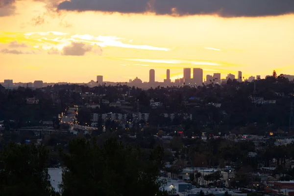 Hillside view of homes and streets with panoramic sky silhouetting downtown skyscrappers — стоковое фото