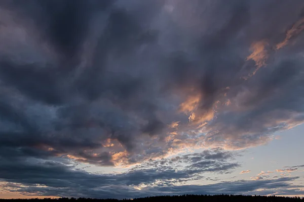 Zonlicht van een ondergaande zon die een bewolkte avond verlicht — Stockfoto