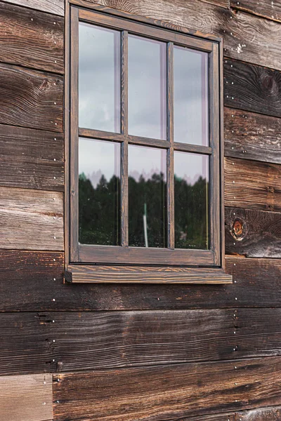 Groot raam op een houten gebouw dat de lucht reflecteren op een bewolkt bewolkte dag — Stockfoto