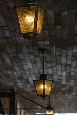 koyu sarı cam kaplı tavandan asılı parlak ışıklar