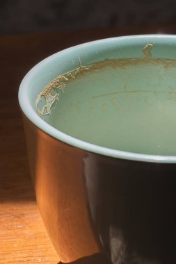 loş ışıklı bir odada bir güneş ışını kullanılan ve boş oturan küçük ışık mavi kupa