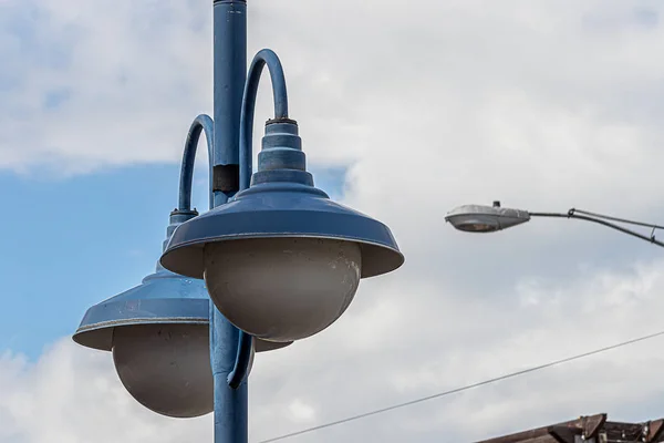 Agrupamento de luzes de rua sobre a estrada contra as nuvens — Fotografia de Stock