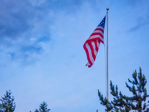 Bandera que ondea en el viento en verano durante el día de julio —  Fotos de Stock