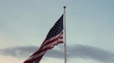 Uzun bir bayrak direğinin tepesinde dalgalanan Amerikan bayrağı
