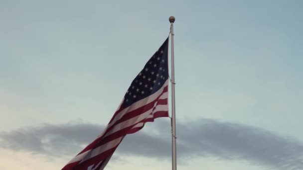 Bandera americana ondeando en la parte superior de un asta de bandera alta — Vídeos de Stock