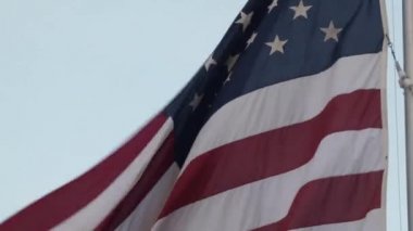 Uzun bir bayrak direğinin tepesinde dalgalanan Amerikan bayrağı